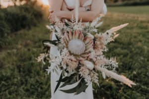 gigantischer Hochzeits blumenstrauss im vintage boho style mit königs protea , pampasgras und trockenblumen