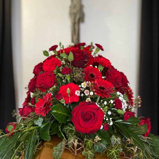 Sargbouquet klassisch mit roten Rosen, Gerbera für christliche Trauerfeier in Baar-Ebenhausen