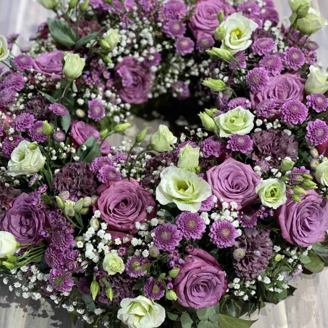Moderne Trauerfloristik - stilvoller Kranzin violett - lila mit Rosen, Lisianthus, Schleierkraut, Nelken, Chrysamtheme