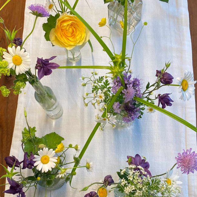 wunderschöne Boho Tischdekoration mit Wiesenblumen und Gräser